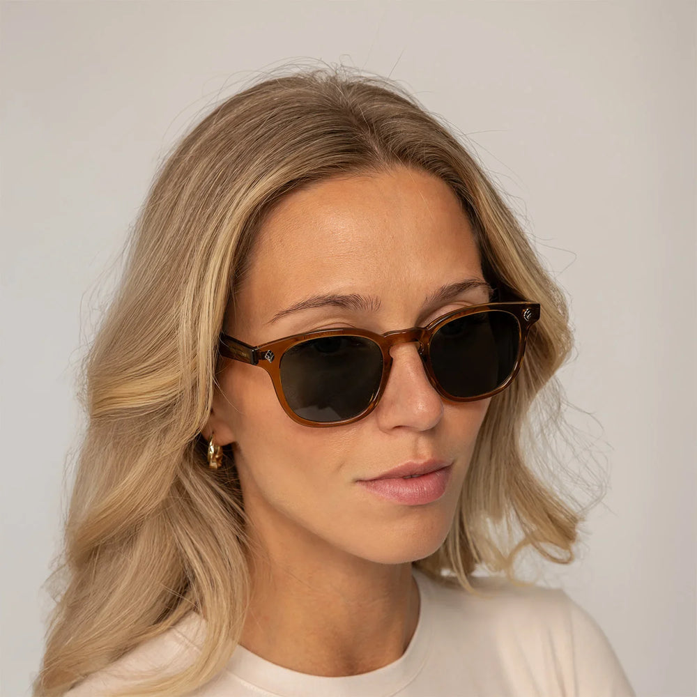 Womean wearing Garrett Leight Ace Sun Sunglasses in Caramel, front view.