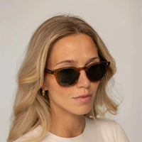 Womean wearing Garrett Leight Ace Sun Sunglasses in Caramel, front view.|caramel