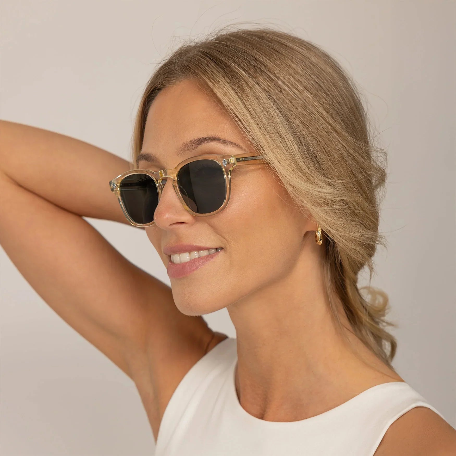 Woman wearing Garrett Leight Ace Sun Sunglasses in Pure Glass, front view.|pure glass