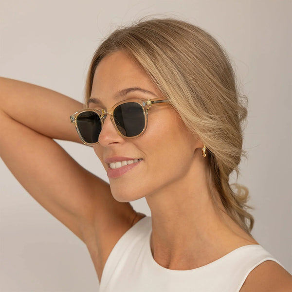 Woman wearing Garrett Leight Ace Sun Sunglasses in Pure Glass, front view.