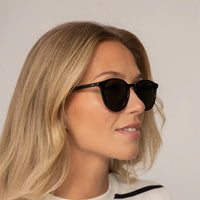 Woman wearing Garrett Leight Clune Sun Sunglasses in Black, front view.