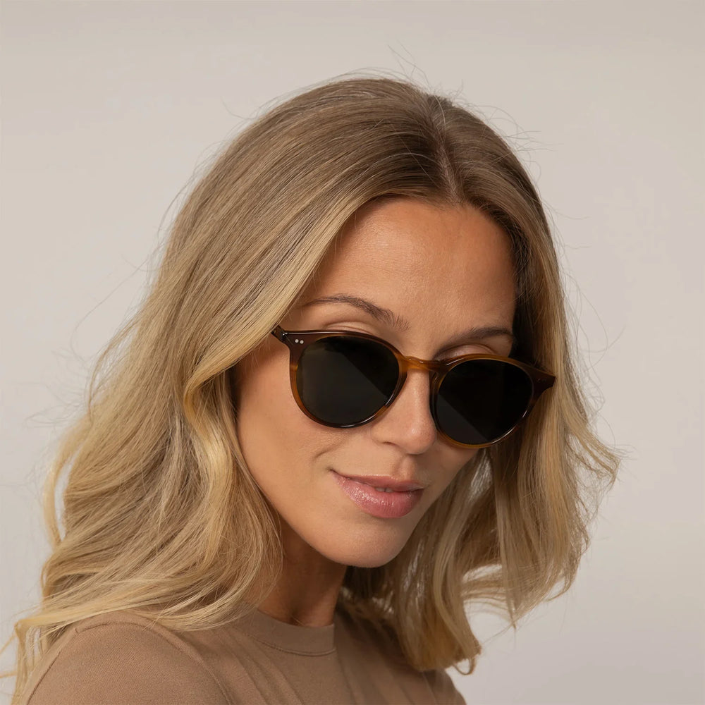 Woman wearing Garrett Leight Clune Sun Sunglasses in True Demi, front view.