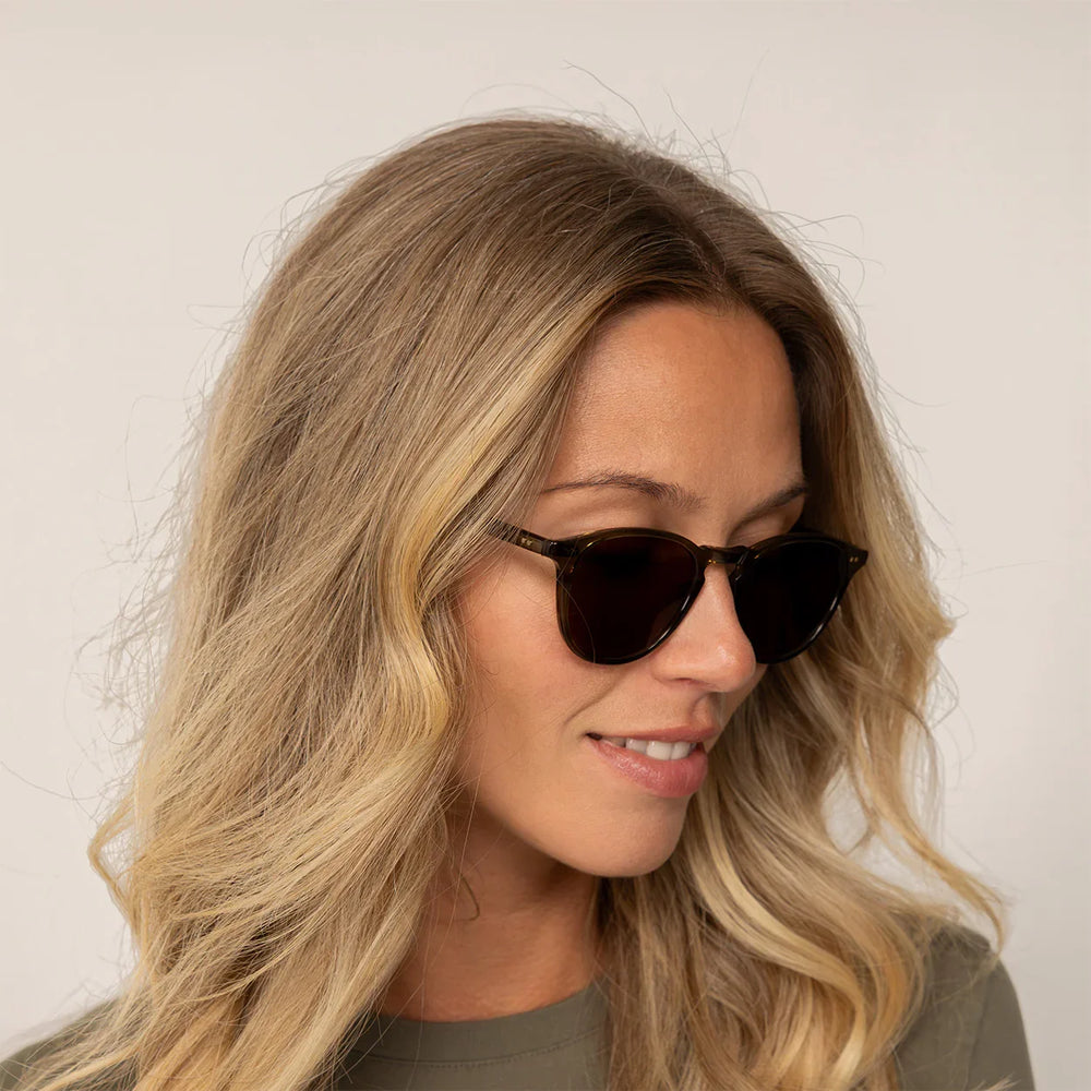 Woman wearing Garrett Leight Hampton Sun Sunglasses in Olive Tortoise, front view.