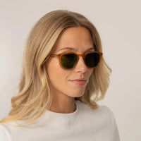 Woman wearing Garrett Leight Kinney Sun Sunglasses in Butterscotch, front view.