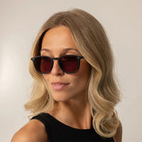 Woman wearing Garrett Leight Kinney Sun Sunglasses in Matte Black, front view.