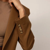 Woman wearing a Marame Classic Blazer in Brown Toffee, closeup.