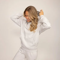 Woman wearing cotton fleece hoodie in Ash White.|ash white