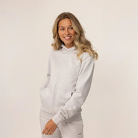 Woman wearing Marame cotton fleece hoodie in Ash White, front view.