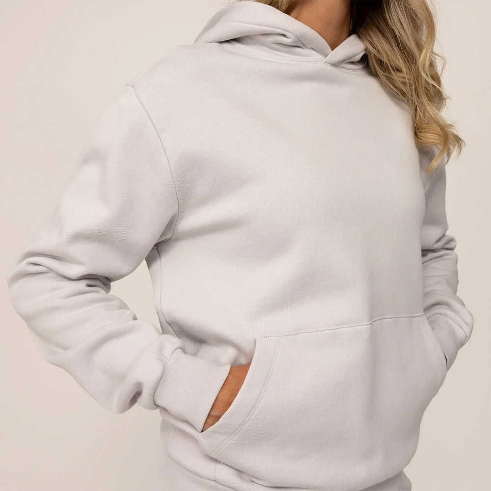 Woman wearing cotton fleece hoodie in Ash White, closeup.
