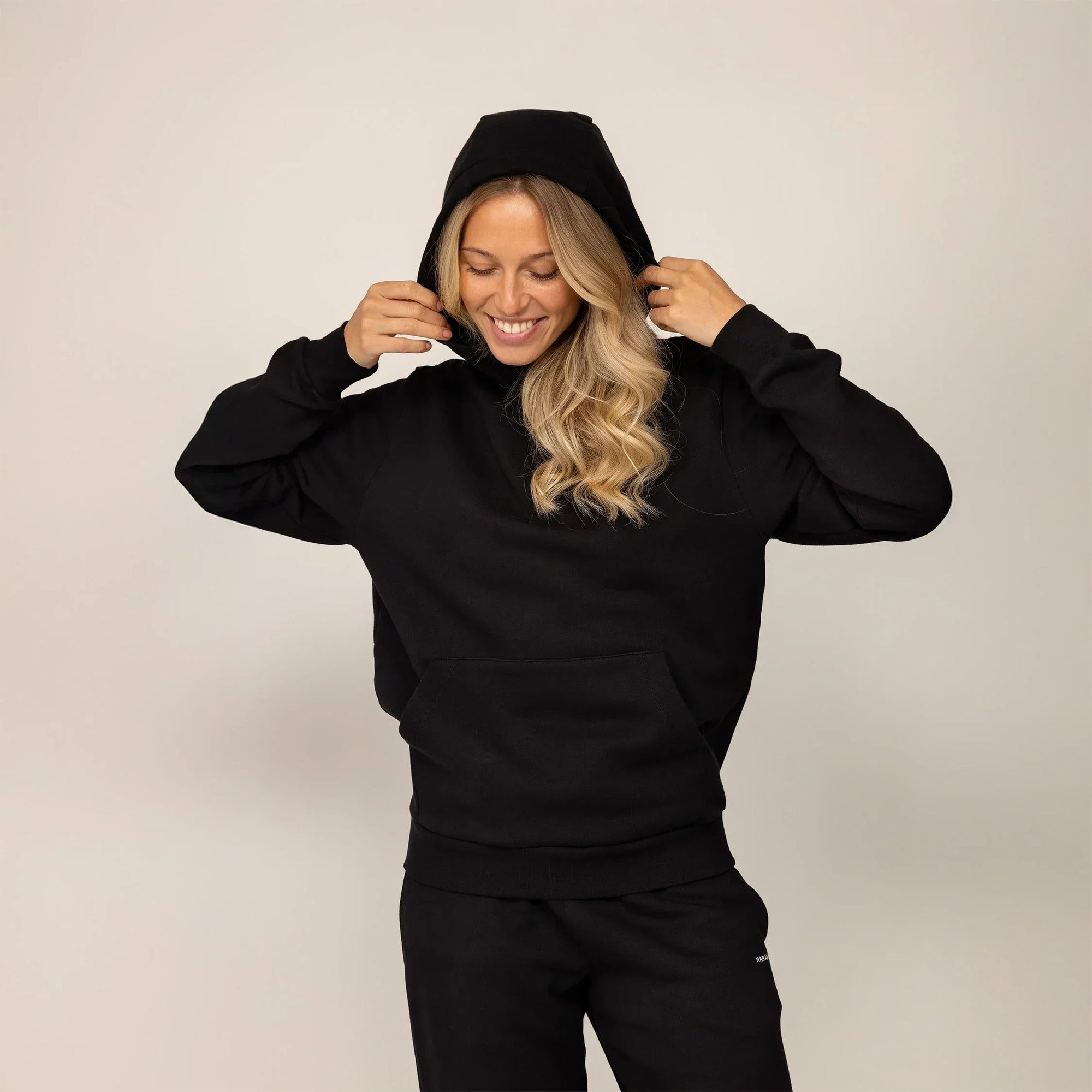 Woman wearing cotton fleece hoodie in Black.|black