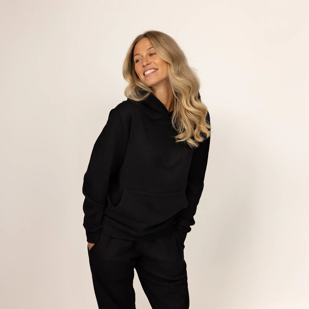 Woman wearing Marame cotton fleece hoodie in Black, front view.