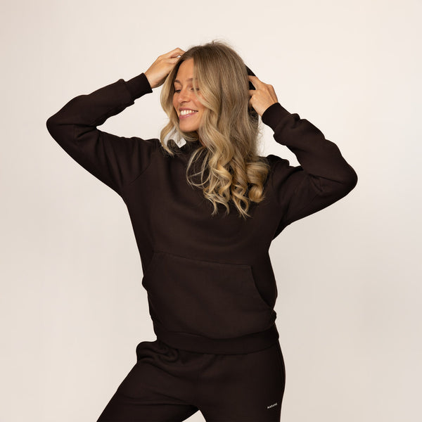 Woman wearing Marame cotton fleece hoodie in Smoked Brown, front view.