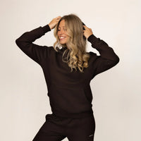 Woman wearing Marame cotton fleece hoodie in Smoked Brown, front view.