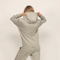 Woman wearing Marame cotton fleece hoodie in Wolf Grey, rear view.|wolf green