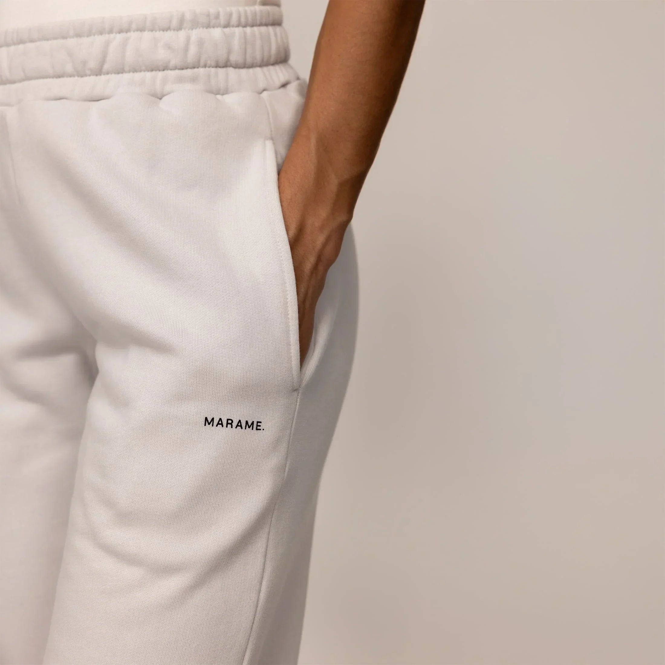Woman wearing cotton fleece Joggers in Ash White, closeup.|ash white