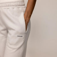 Woman wearing cotton fleece Joggers in Ash White, closeup.|ash white