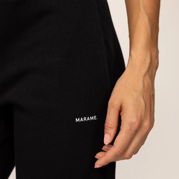 Woman wearing Marame cotton fleece Joggers in Black, closeup.|black