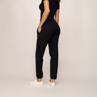Woman wearing cotton fleece Joggers in Black, rear view.
