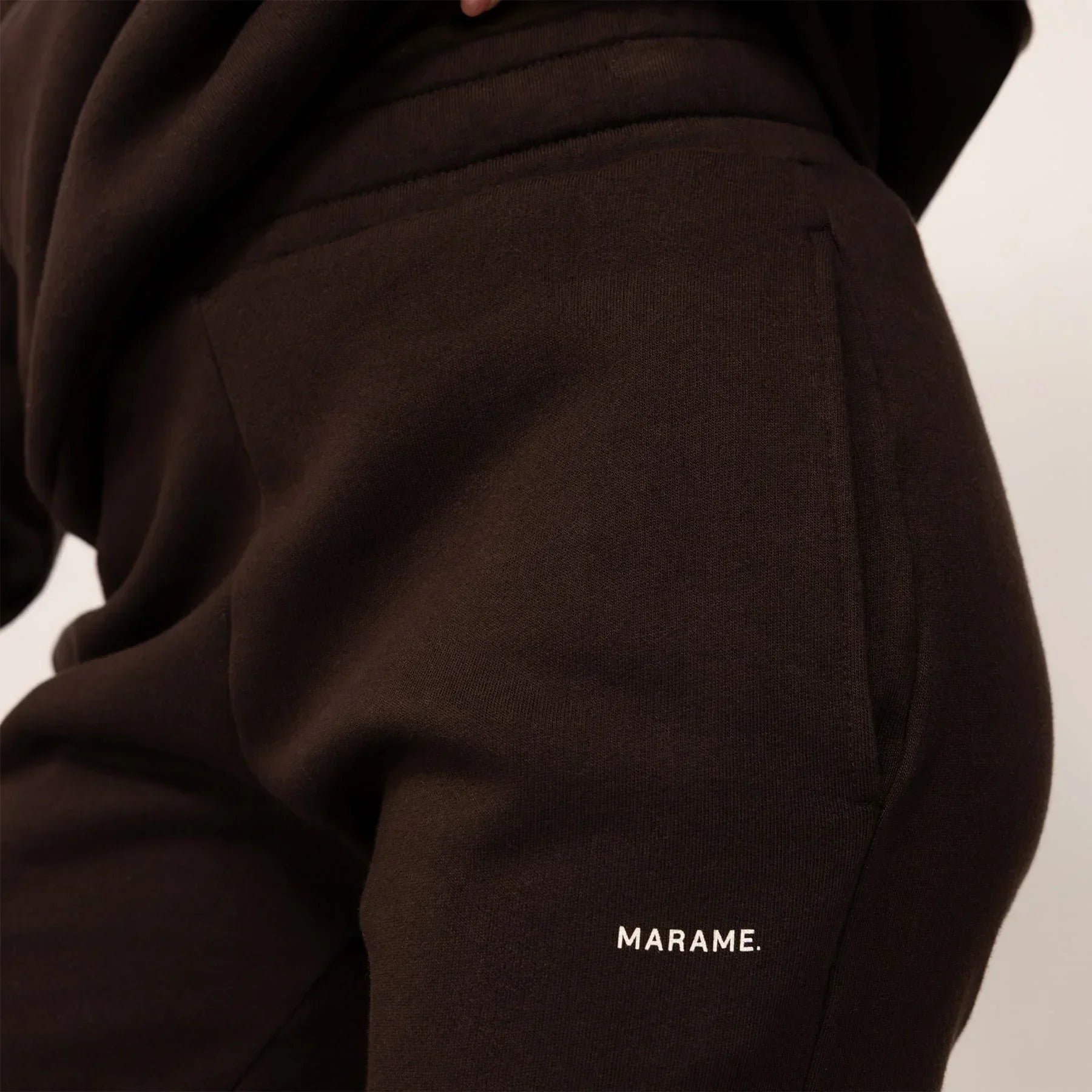 Woman wearing cotton fleece Joggers in Smoked Brown, closeup.|smoked brown
