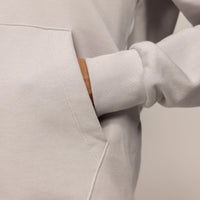 Woman wearing a cotton fleece Logo Hoodie in Ash White, detail.