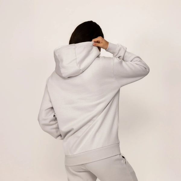 Woman wearing a cotton fleece Logo Hoodie in Ash White, rear view.