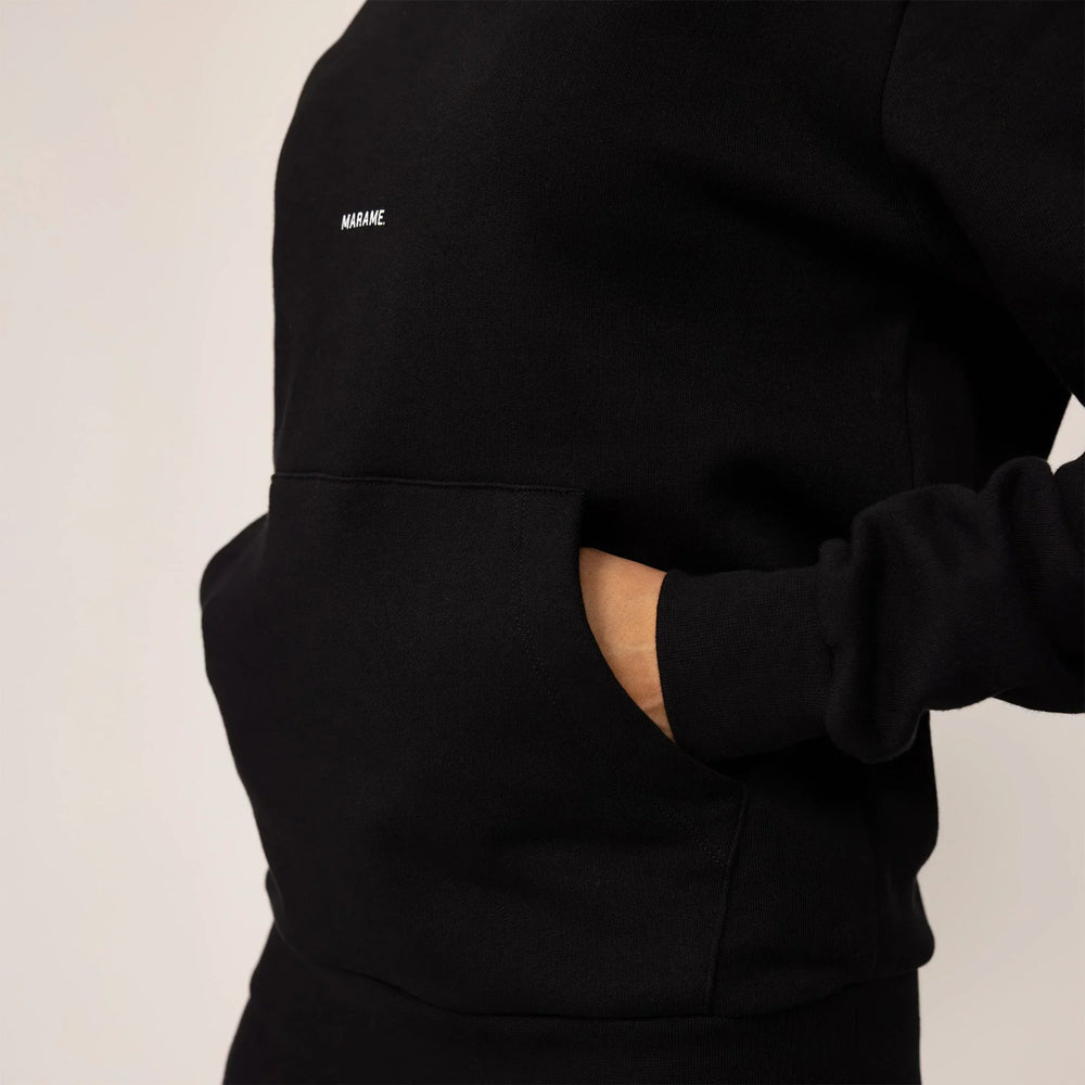Woman wearing cotton fleece Logo Hoodie in Black, closeup.