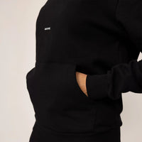 Woman wearing cotton fleece Logo Hoodie in Black, closeup.|black