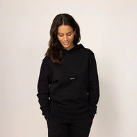 Woman wearing cotton fleece Logo Hoodie in Black, front view.