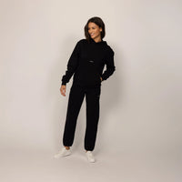 Woman wearing Marame cotton fleece Logo Hoodie in Black, full view.