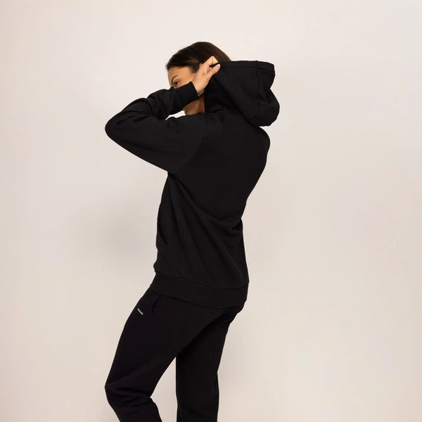 Woman wearing Marame cotton fleece Logo Hoodie in Black, rear view.|black