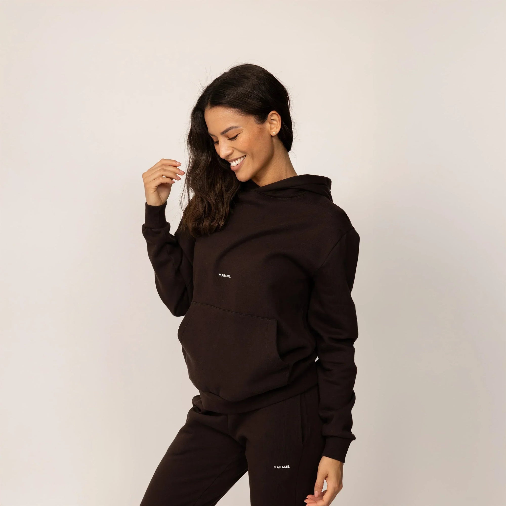 Woman wearing cotton fleece Logo Hoodie in Smoked Brown, front view.|smoked brown