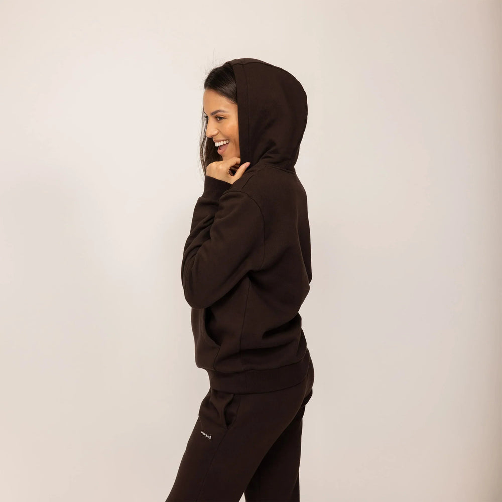 Woman wearing cotton fleece Logo Hoodie in Smoked Brown, side view.|smoked brown