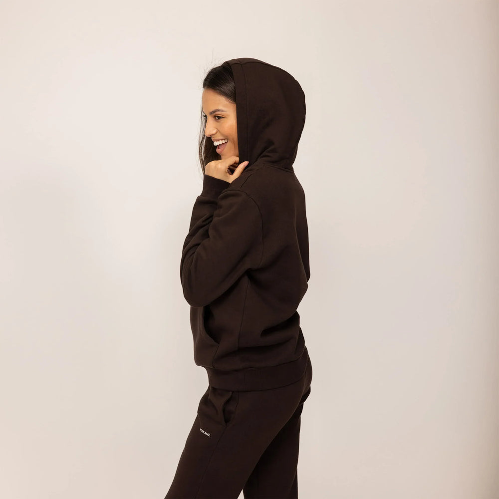 Woman wearing cotton fleece Logo Hoodie in Smoked Brown, side view.