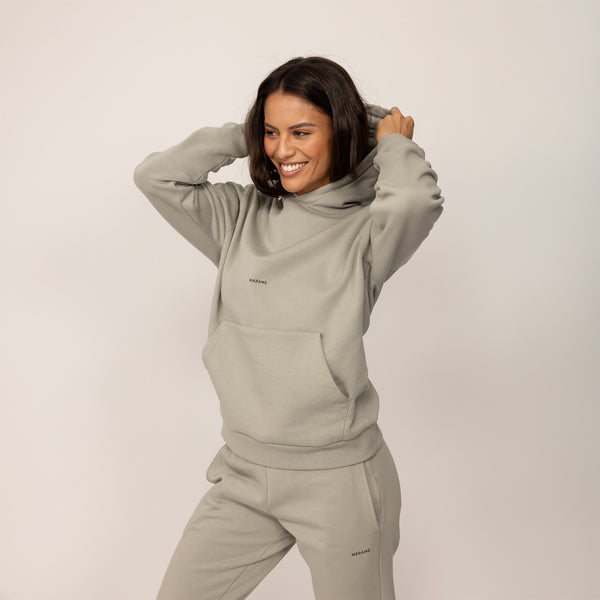 Woman wearing a Marame cotton fleece Logo Hoodie in Wolf Grey, front view.