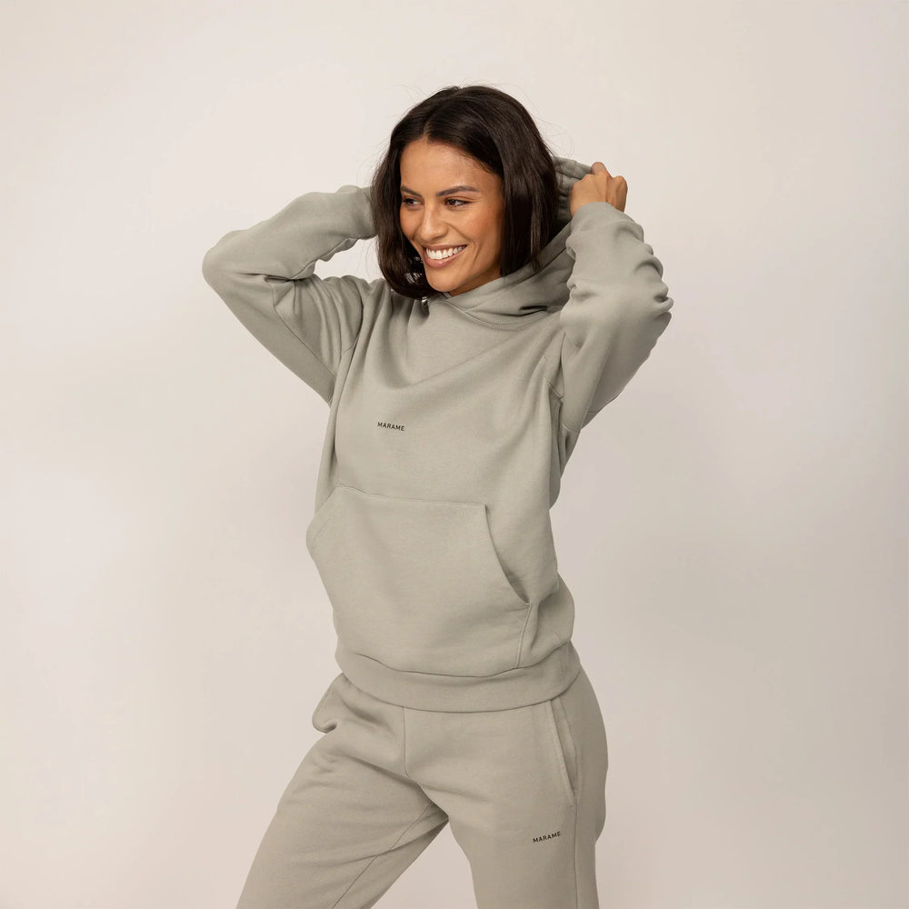 Woman wearing a Marame cotton fleece Logo Hoodie in Wolf Grey, front view.