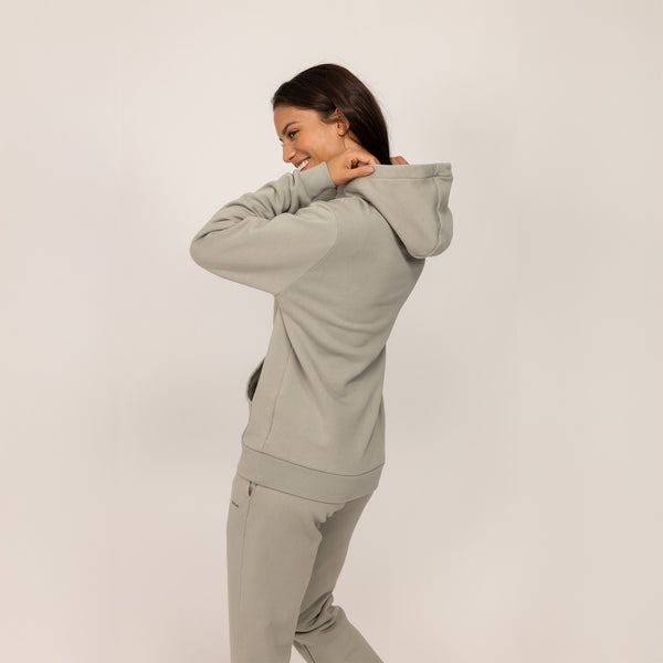 Woman wearing a cotton fleece Logo Hoodie in Wolf Grey, rear view.