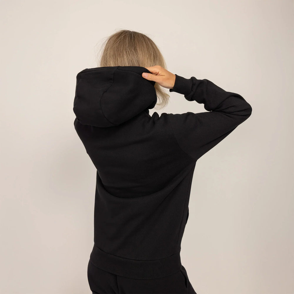 Woman wearing cotton fleece hoodie in Black, rear view.