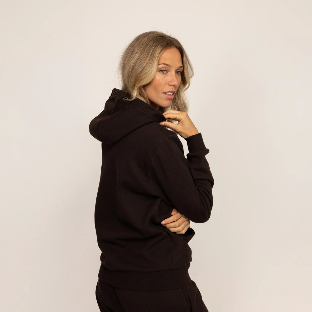Woman wearing cotton fleece hoodie in Smoked Brown, rear view.