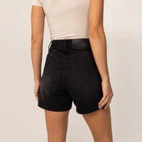 Woman wearing Marame Denim Shorts in Black Wash Denim, rear view.