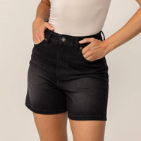 Woman wearing Marame Denim Shorts in Black Wash Denim, front view.