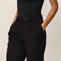 Woman wearing Marame High-Waisted Smart Trousers in Black, closeup.