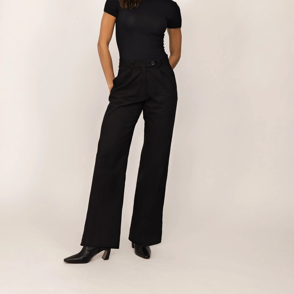 Woman wearing Marame High-Waisted Smart Trousers in Black, front view.