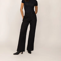 Woman wearing Marame High-Waisted Smart Trousers in Black, front view.