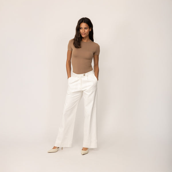 Woman wearing Marame High-Waisted Smart Trousers in White Cream, full view.