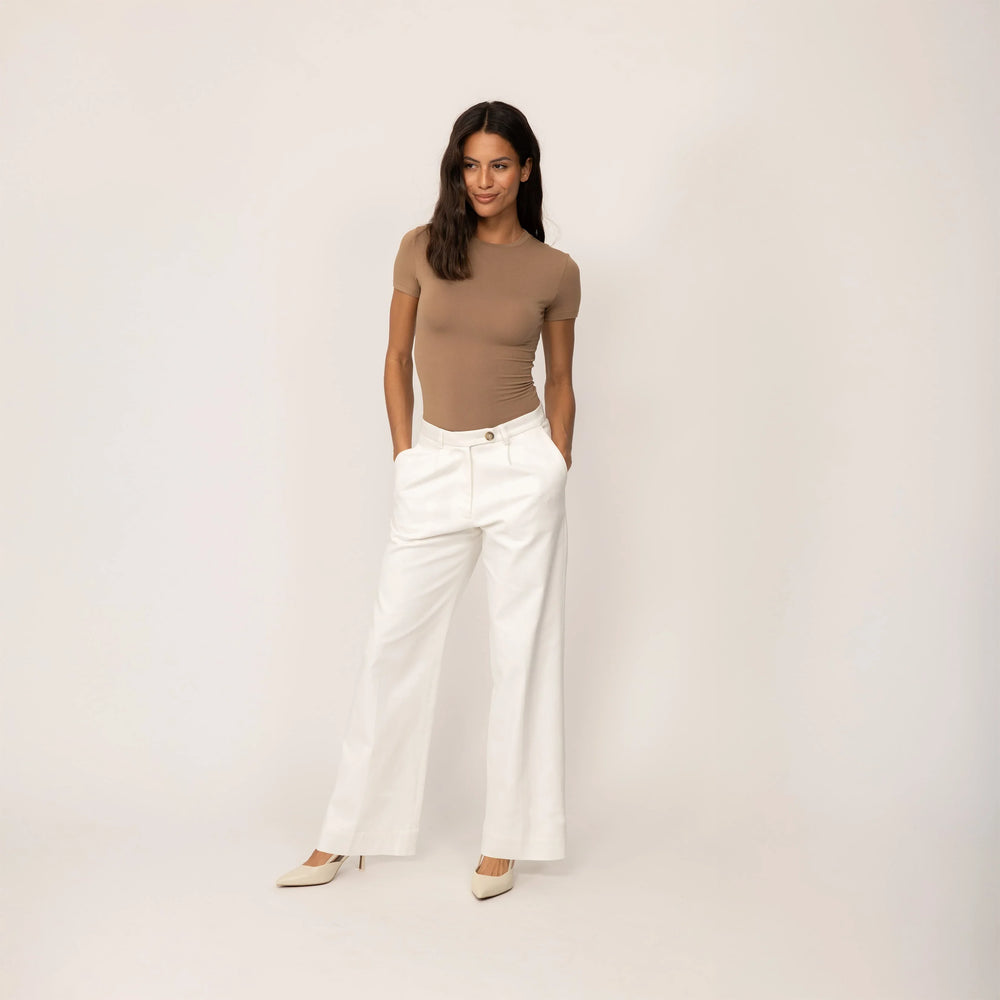 Woman wearing Marame High-Waisted Smart Trousers in White Cream, full view.