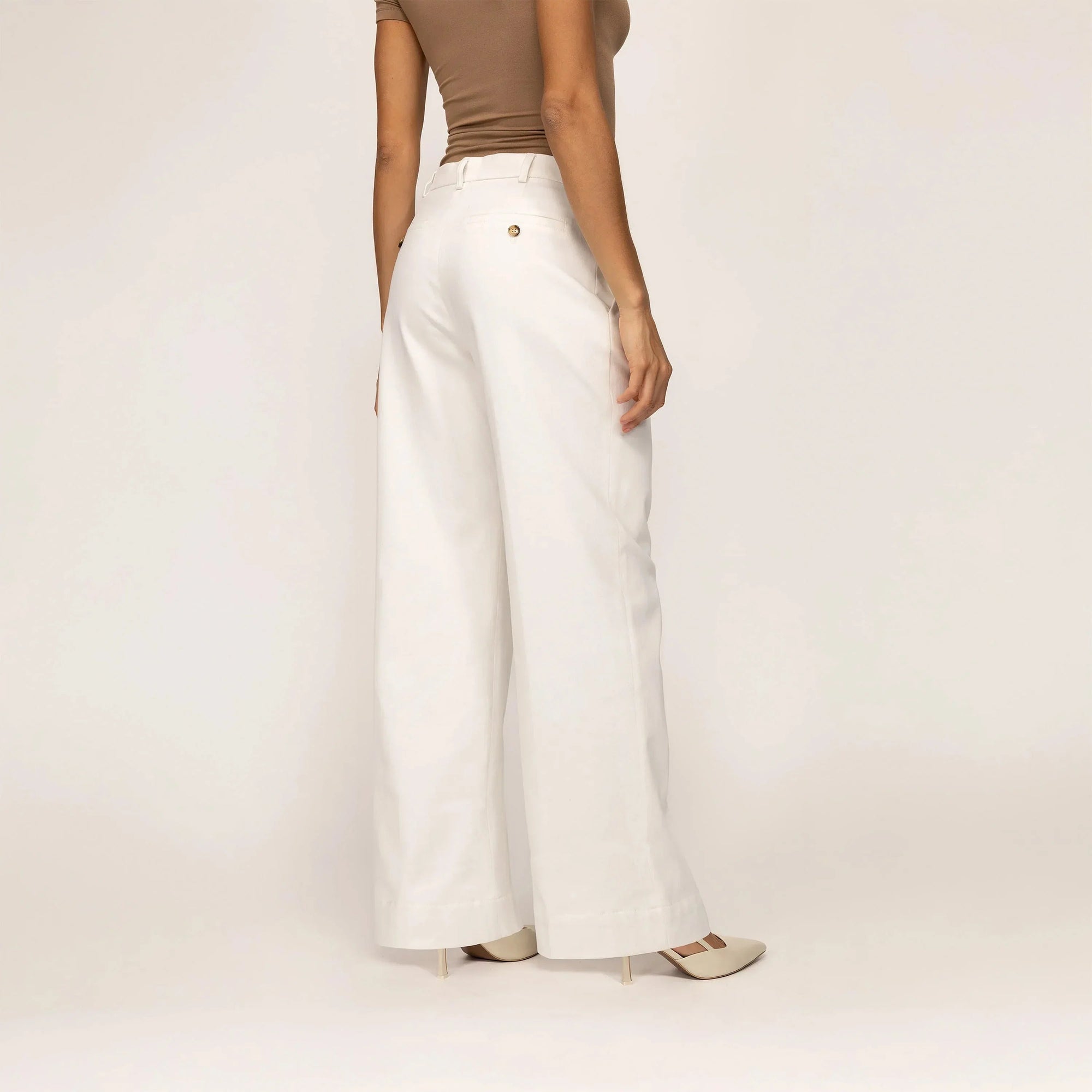 Woman wearing Marame High-Waisted Smart Trousers in White Cream, rear view. |white cream