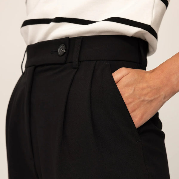 Woman wearing High-Waisted Tapered Trousers in Black, closeup.