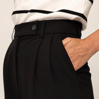 Woman wearing High-Waisted Tapered Trousers in Black, closeup.