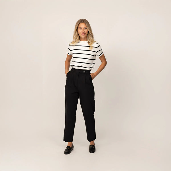 Woman wearing Marame High-Waisted Tapered Trousers in Black, front view.