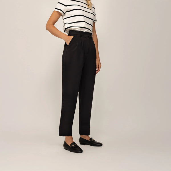 Woman wearing Marame High-Waisted Tapered Trousers in Black, front view.